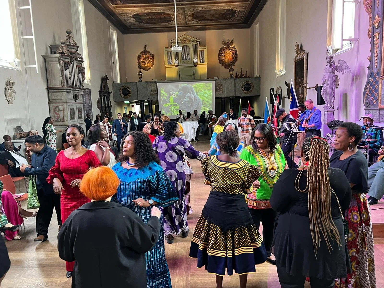 Guests dancing in a hall decorated with flags