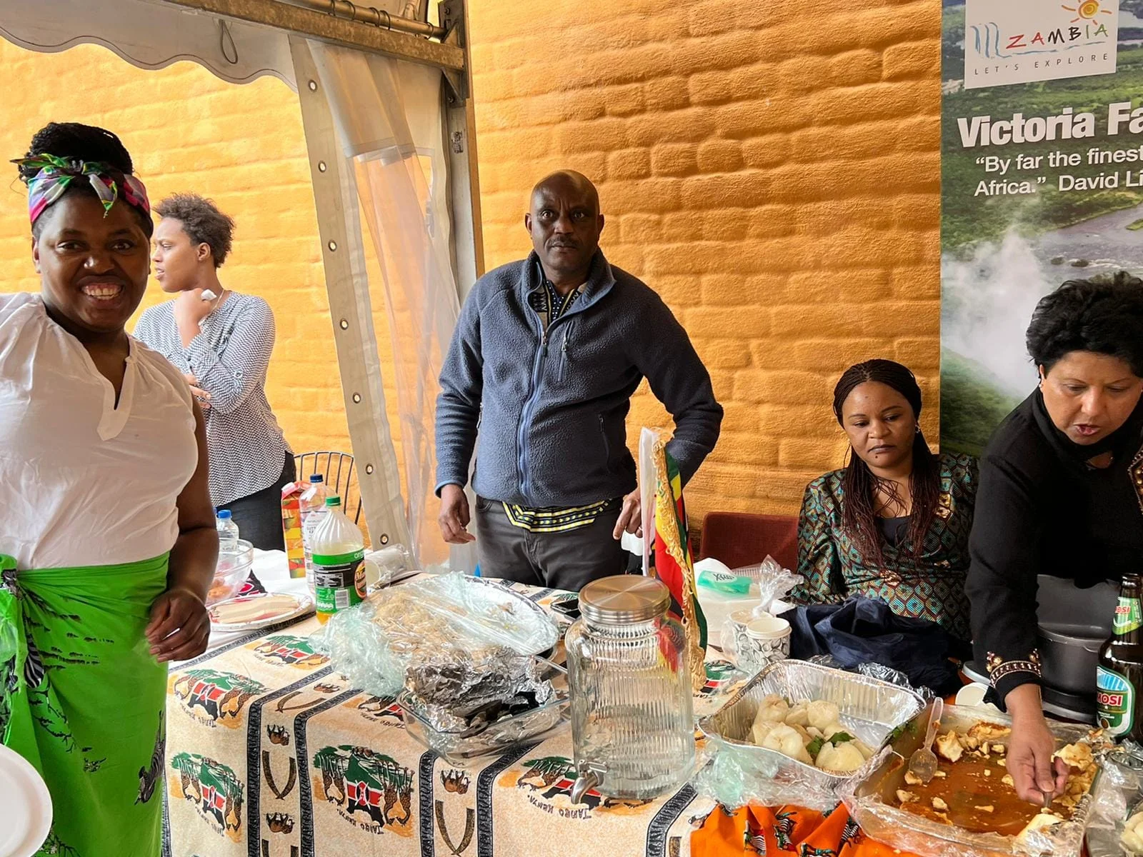 Guests at a table of food and Zimbabwean crafts